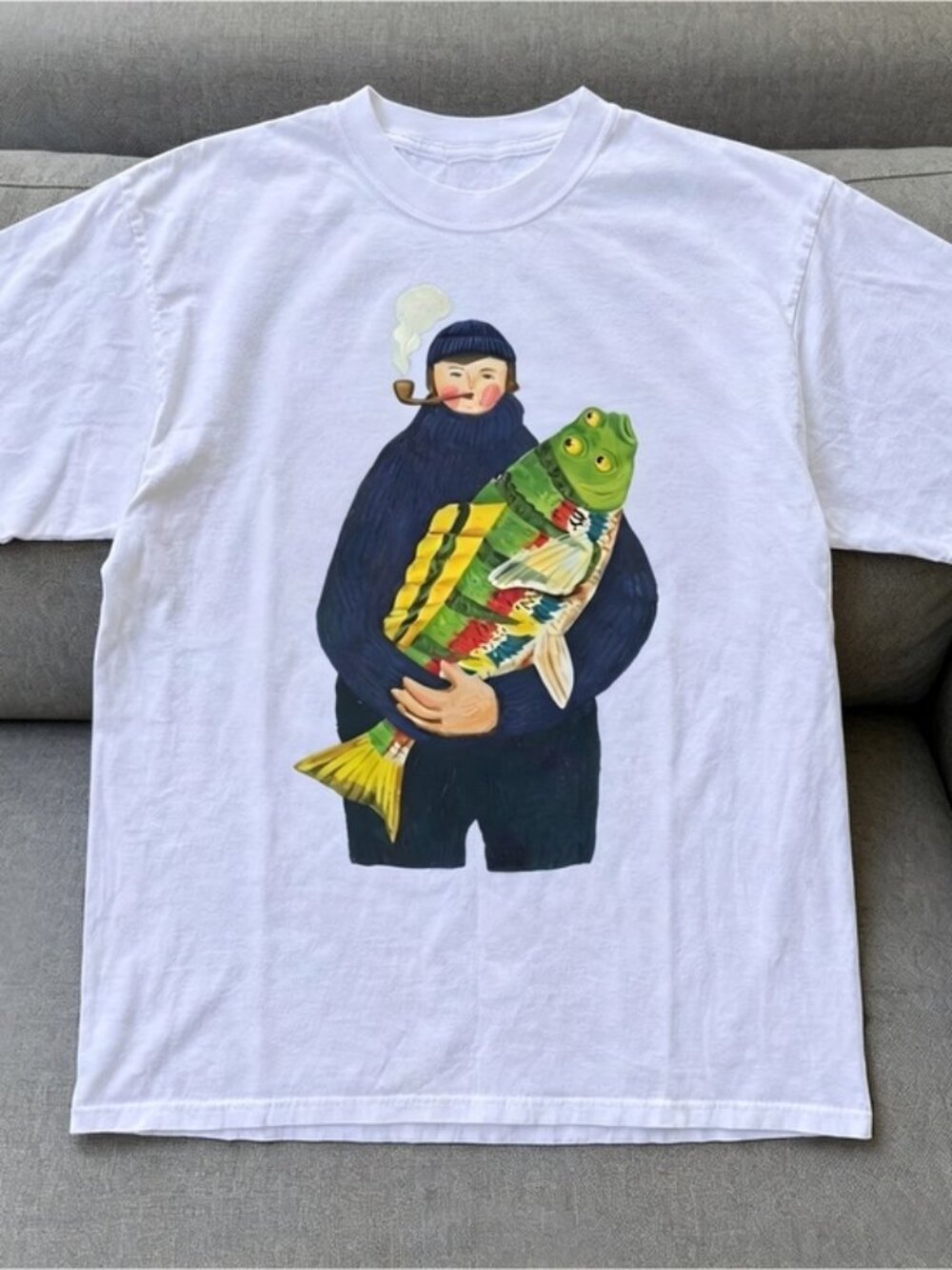 White t-shirt graphic ith a man holding colorful fish Women Men T-shirt unisex